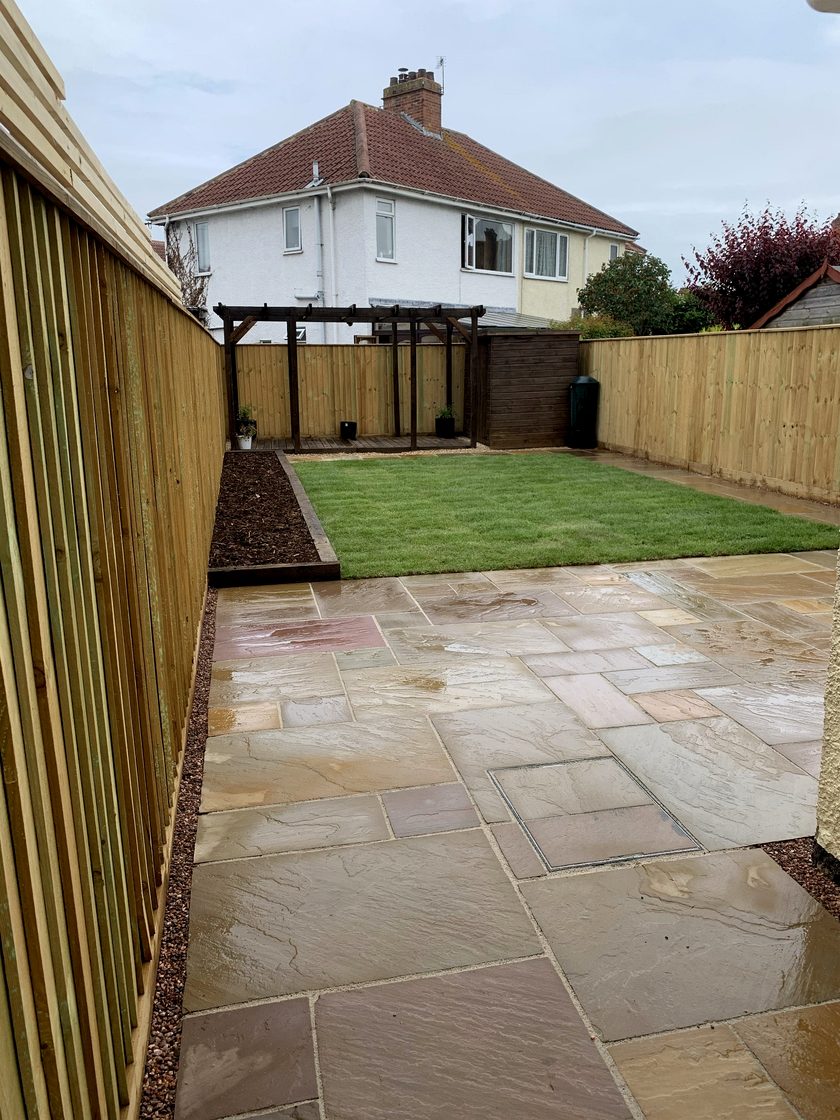 Completed garden transformation with sandstone patio, lawn, fencing and pergola