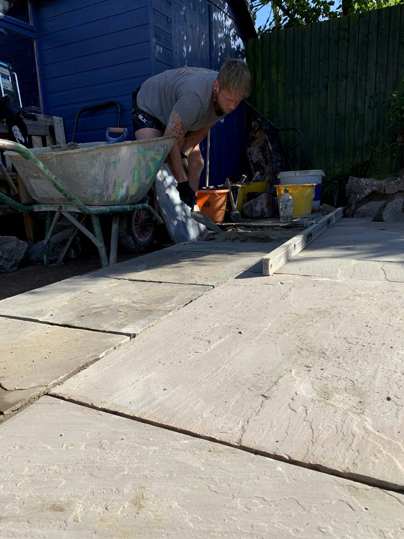 James laying natural stone paving on a garden project